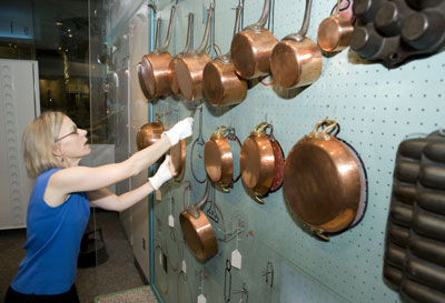 Curator Paula Johnson installs copper pots on Julia Child’s blue-painted pegboard in the Julia Child's Kitchen exhibition at the National Museum of American History, July 29, 2009.  http://americanhistory.si.edu/index.cfm